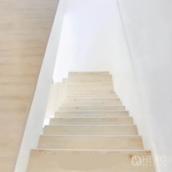 带办公室的家 出租或出售在Phra Khanong, Bangkok - 从上向下俯视浅木色楼梯与白色墙面。