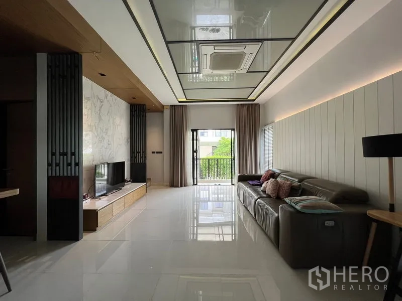 联排别墅 出租在Saphan Sung, Bangkok - 狭长客厅，电视墙、阳台门与风管式空调吊顶。