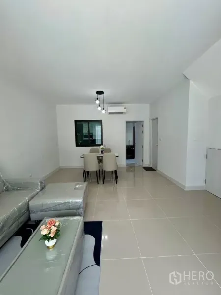 Townhouse for rent in Bang Phli, Samut Prakan - Open-plan lounge and dining area with glossy tile floors and ceiling lights.