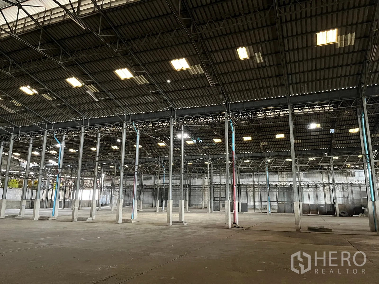 Warehouse for rent in Rat Burana, Bangkok - Wide-bay warehouse hall with multiple steel columns and overhead lighting.