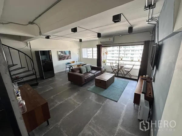 Condominium for rent in Watthana, Bangkok - Living area featuring a spiral staircase, large windows and a balcony seating nook.