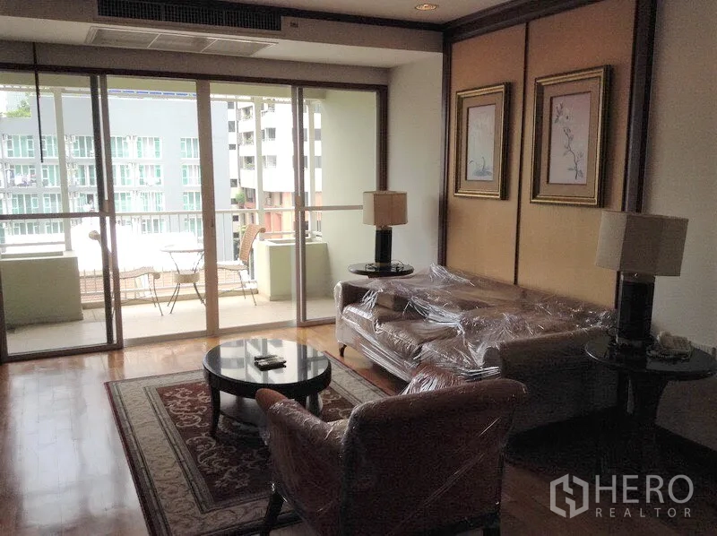 คอนโด ให้เช่าหรือขายในWatthana, Bangkok - ห้องนั่งเล่นพื้นไม้ เปิดสู่ระเบียงพร้อมชุดโต๊ะและวิวเมืองในคอนโดกรุงเทพฯ