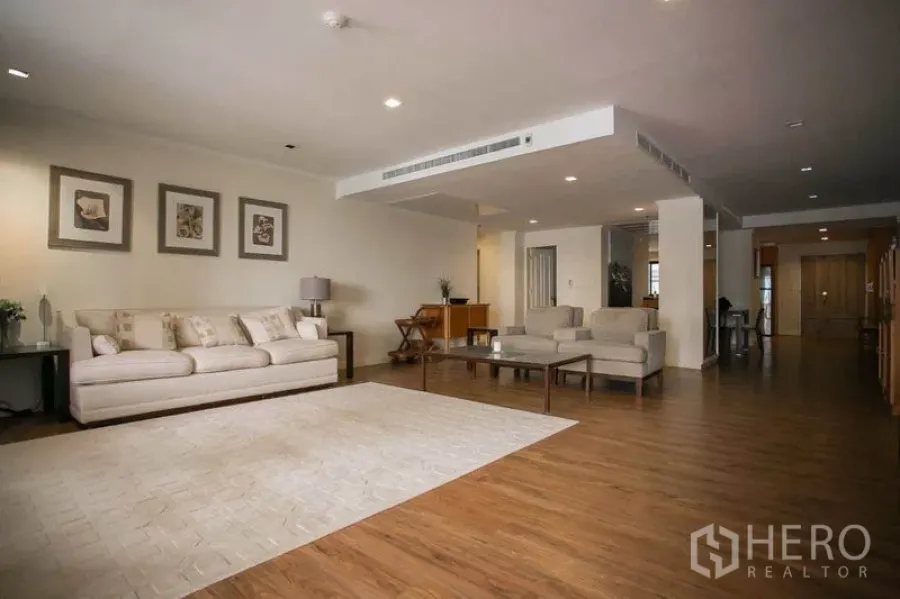 คอนโด ให้เช่าหรือขายในWatthana, Bangkok - ห้องนั่งเล่นกว้าง พื้นไม้ โซฟาสีครีม และไฟดาวน์ไลท์
