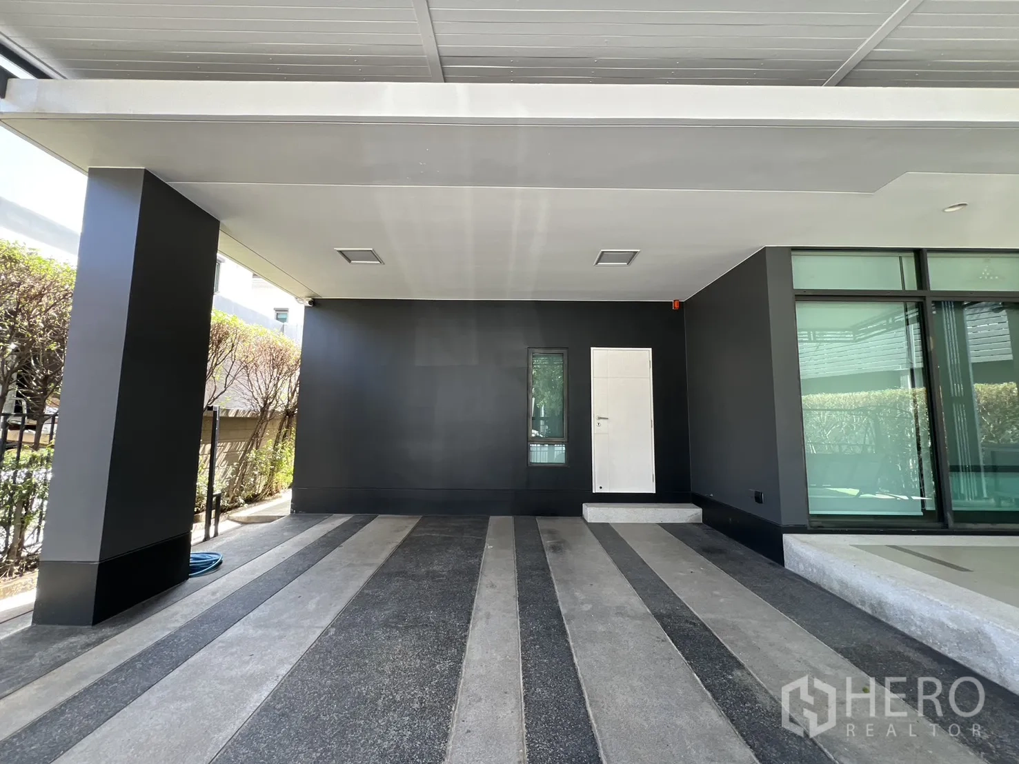 独立式住宅 出售在Bang Kapi, Bangkok - 带顶双车位车库，深色特色墙与入户门。