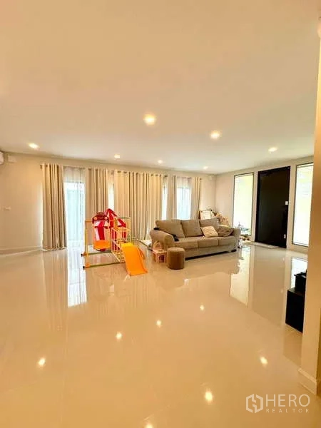 บ้าน ขายในLat Krabang, Bangkok - พื้นที่นั่งเล่นแบบเปิดโล่ง พื้นเงา ผ้าม่าน และมุมเล่นเด็ก