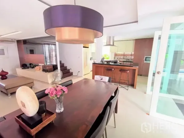 Detached House for rent or sale in Bang Phli, Samut Prakan - Open-plan dining area with large pendant light facing island kitchen and bar stools.