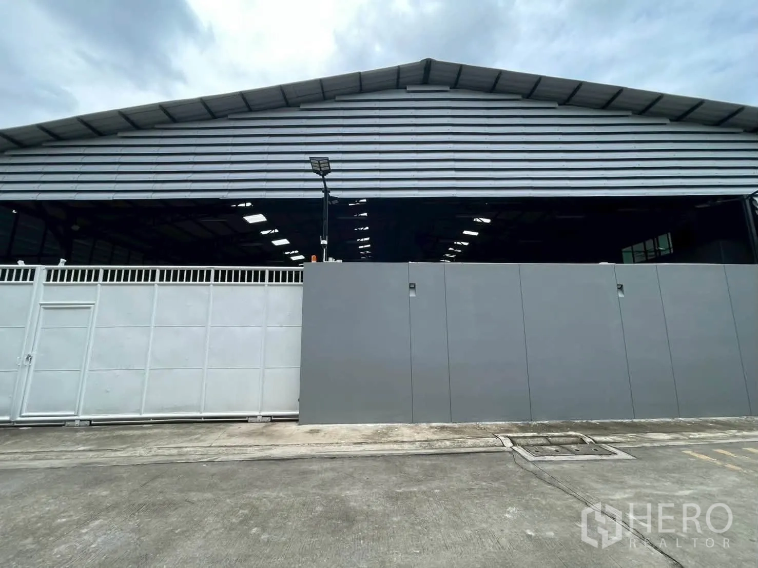 โกดัง for rent in Taling Chan, Bangkok - ด้านหน้าโกดังหลังคาเมทัลชีทอยู่หลังประตูบานเลื่อนขนาดใหญ่.