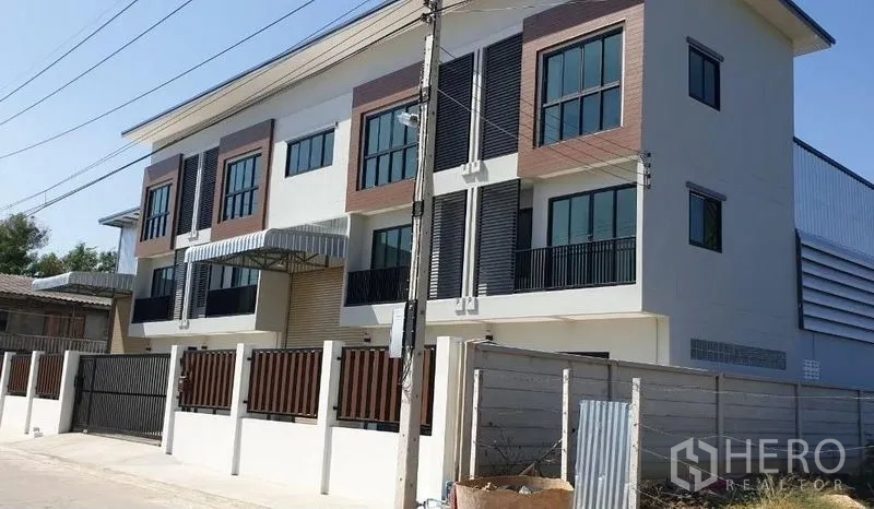Factory for rent in Lam Luk Ka, Pathum Thani - Modern three-storey factory exterior in Lam Luk Ka with gated driveway and loading canopy.