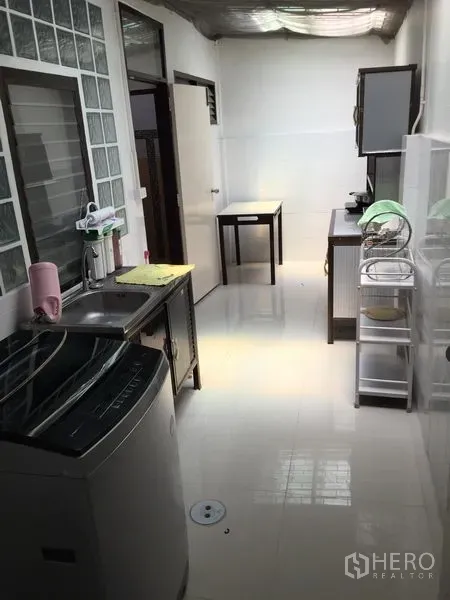 ทาวน์เฮาส์ ให้เช่าในPhra Khanong, Bangkok - ครัวแคบยาวสว่าง พร้อมอ่างล้างจาน เครื่องซักผ้า และผนังกระจกบล็อก