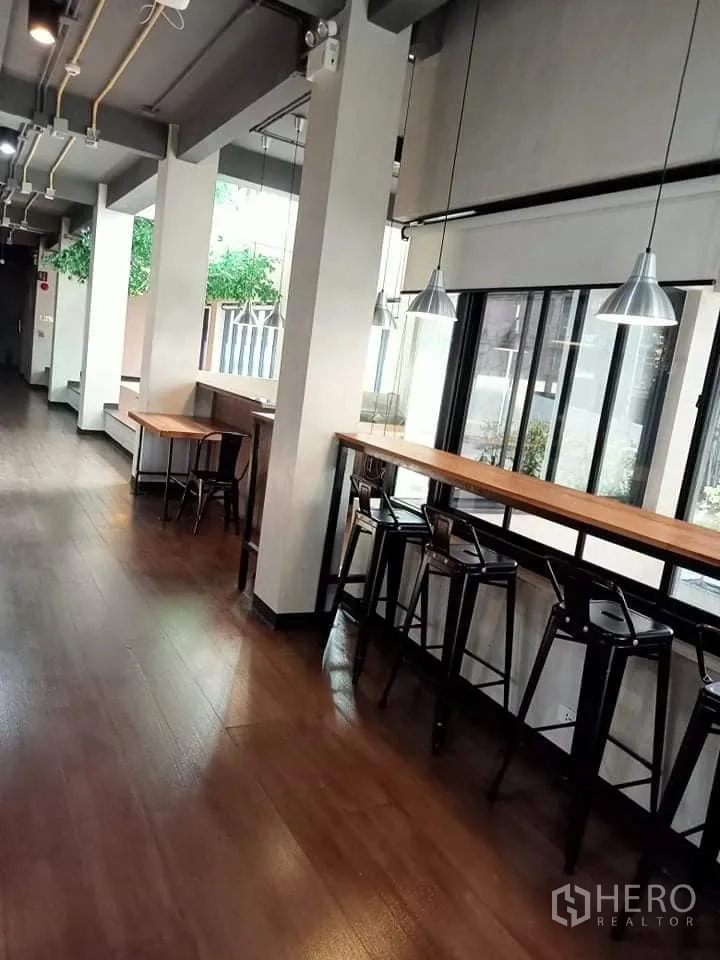 สำนักงาน ให้เช่าในPhra Khanong, Bangkok - พื้นที่ทำงานริมหน้าต่าง มีเคาน์เตอร์บาร์ เก้าอี้สูง พื้นไม้ และไฟแขวน