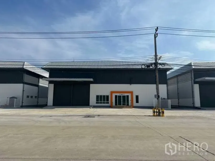 โรงงาน ให้เช่าในBang Sao Thong, Samut Prakan - ด้านหน้าโรงงานสมัยใหม่ ประตูม้วนขนาดใหญ่ ทางเข้าออฟฟิศกระจก และลานคอนกว้าง