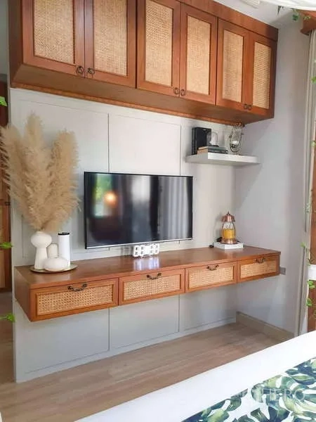 Detached House for sale in Bang Phli, Samut Prakan - Built-in TV wall with rattan-front cabinets and a floating shelf in the bedroom