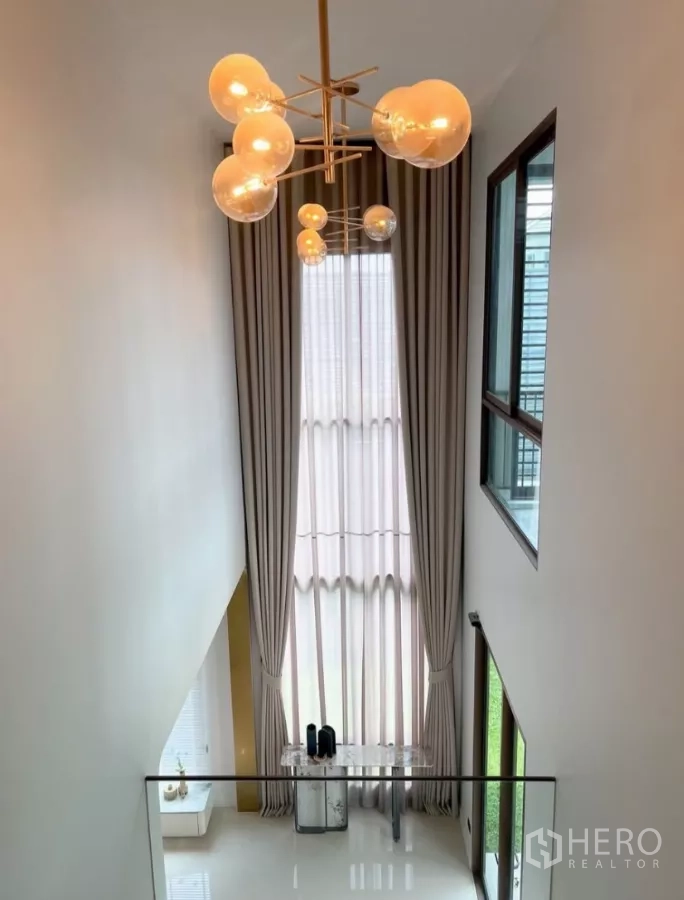Detached House for rent or sale in Bang Kapi, Bangkok - Double-height foyer with dramatic chandelier and glass balustrade.