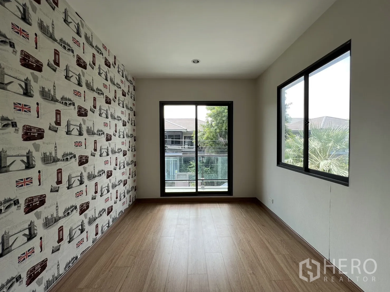 Detached House for sale in Suan Luang, Bangkok - Bedroom with London-themed wallpaper and balcony outlook.