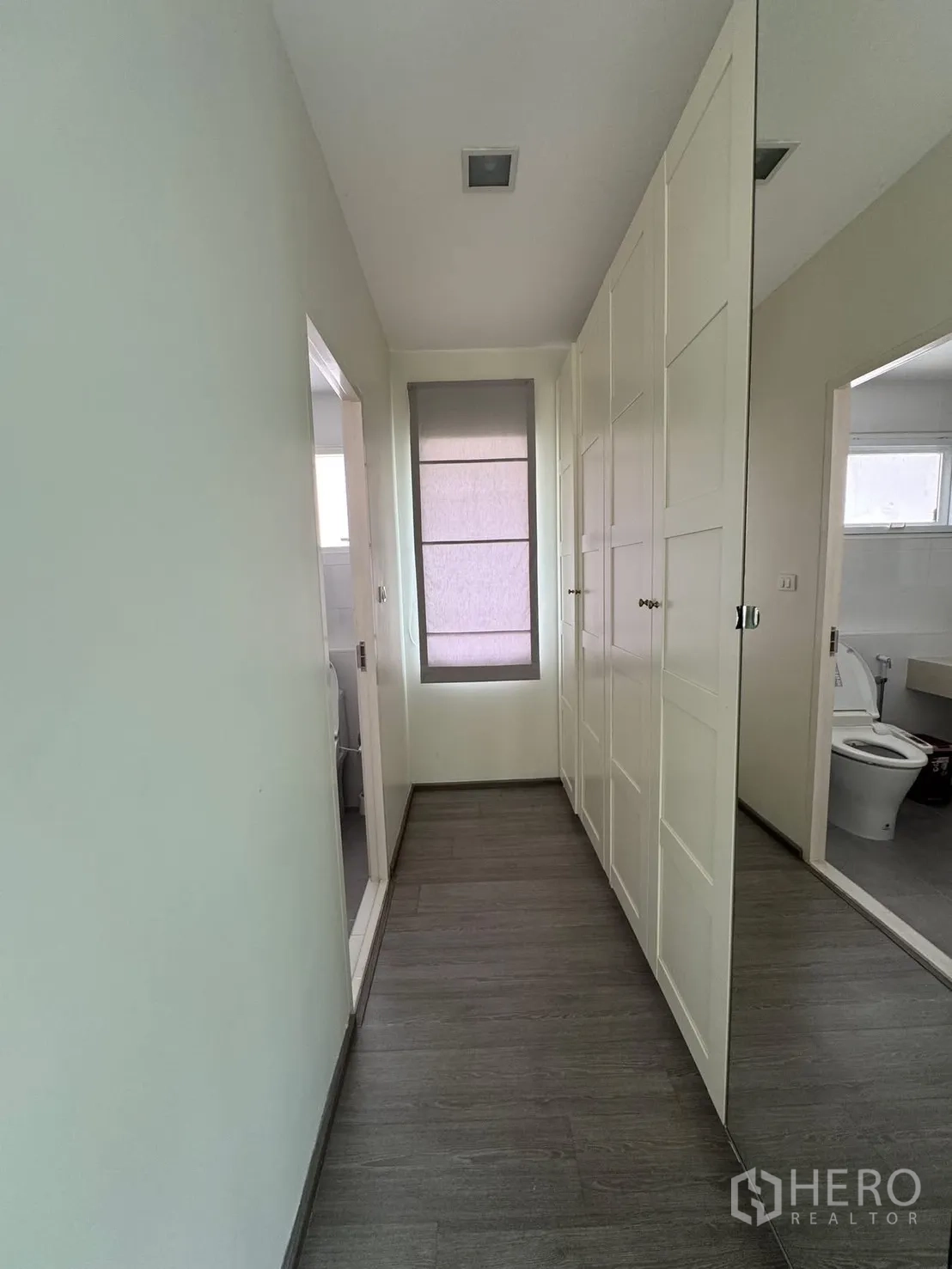 Detached House for rent in Bang Phli, Samut Prakan - Hallway with full-height wardrobes and mirror beside bathroom entrance.