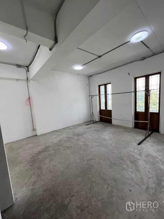 零售空间 出租在Khlong Toei, Bangkok - 大型白色工作室，双阳台门与吸顶灯。