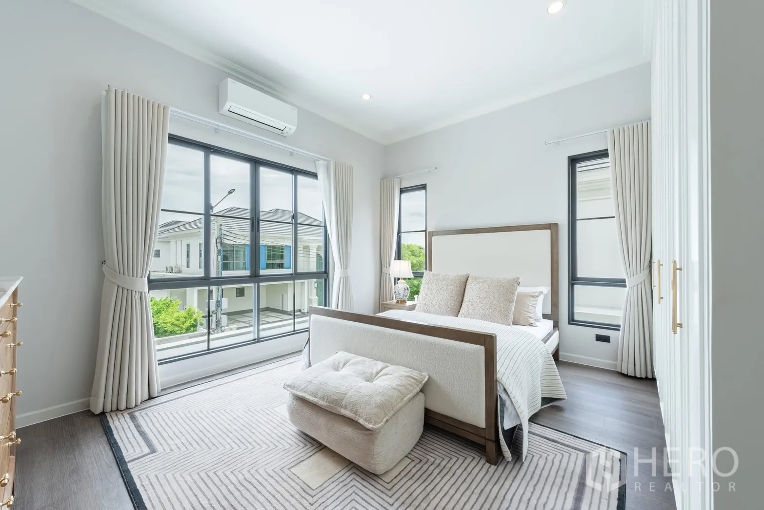 Detached House for rent or sale in Bang Phli, Samut Prakan - Bedroom with large sliding windows and balcony view, light drapes, and area rug.