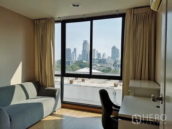 คอนโด ขายในWatthana, Bangkok - ห้องนอน/ห้องทำงาน พร้อมโซฟา โต๊ะทำงาน และหน้าต่างบานใหญ่เห็นวิวสกายไลน์