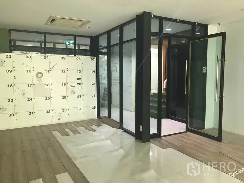 零售空间 出租在Watthana, Bangkok - 玻璃入口双开门，全高门框，旁设储物柜区。