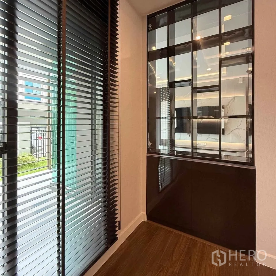 Detached House for rent in Bang Phli, Samut Prakan - Entry nook with glass display cabinet and window blinds to the garden.