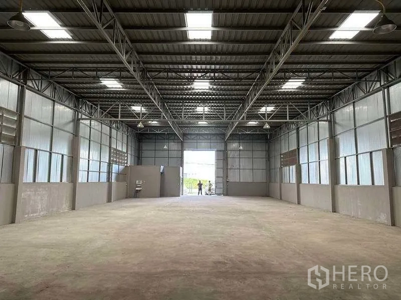 货栈 出租在Mueang Pathum Thani, Pathum Thani - 高挑钢结构仓库内部，天窗采光，混凝土地面