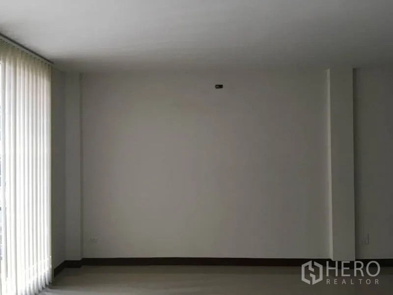 Home Office for rent in Lat Krabang, Bangkok - Bright empty room with large window and vertical blinds, ready for workspace setup.