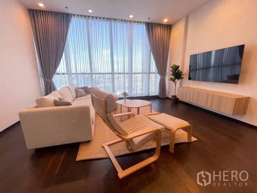 Condominium for rent in Phra Khanong, Bangkok - Bright living room with floor-to-ceiling windows, city skyline view, sofa set and wall‑mounted TV.