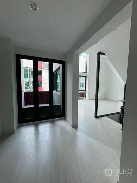 Townhouse for rent - Entry foyer with black-framed double doors and view toward the staircase.