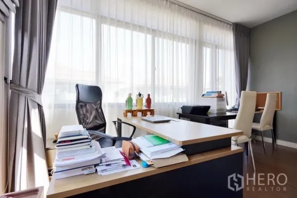独立式住宅 出租或出售在Bang Kapi, Bangkok - 转角书房，L型书桌、行政椅，长窗与轻薄窗帘。