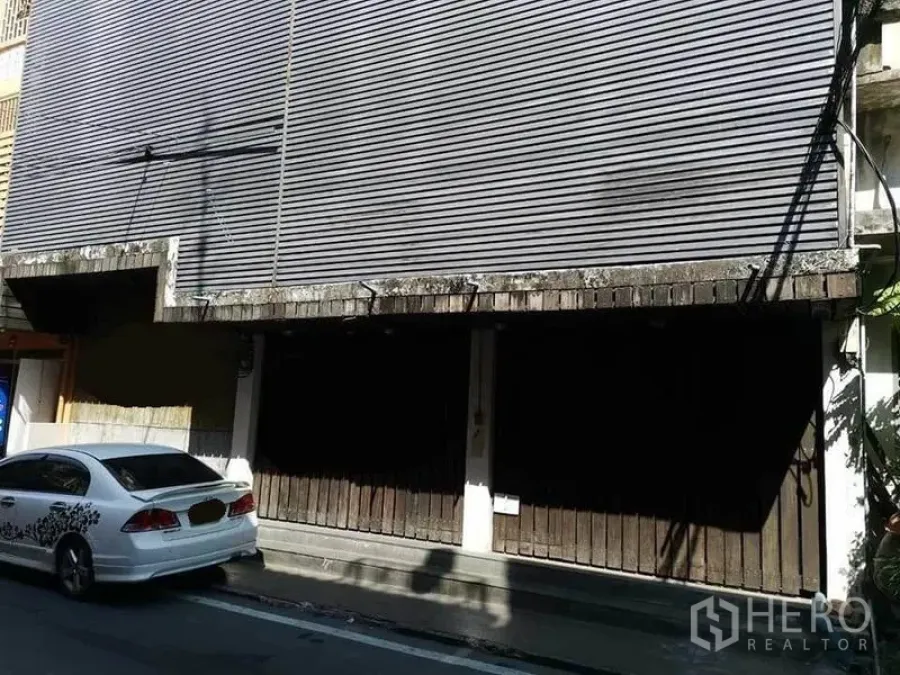 Home Office for rent in Khlong Toei, Bangkok - Street-facing shophouse facade with metal shutters and roadside parking.