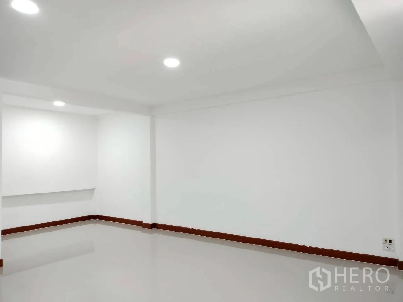 Home Office for rent in Watthana, Bangkok - Clean white room with recessed lighting and polished floors.