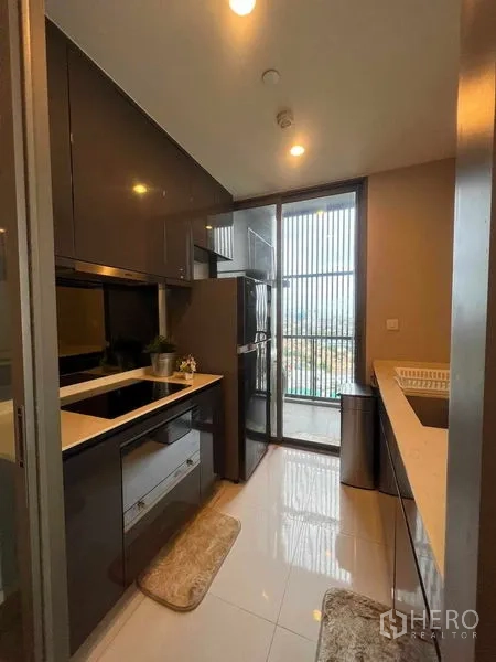 คอนโด ให้เช่าในKhlong Toei, Bangkok - ครัวปิดสไตล์โมเดิร์น ตู้บิลท์อิน เตาและตู้เย็น พร้อมทางออกสู่ระเบียง