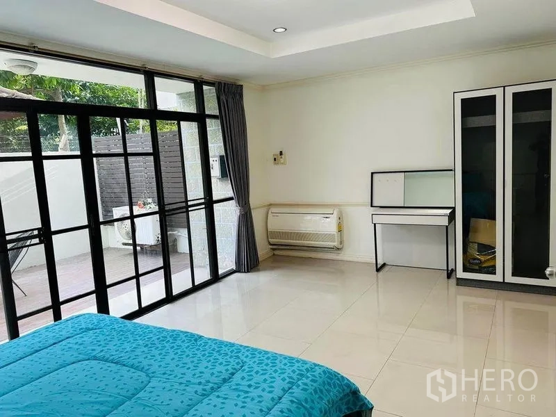 Home Office for rent in Watthana, Bangkok - Bedroom opening to a terrace through sliding glass doors, with wardrobe and vanity.