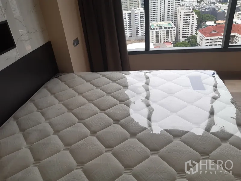 คอนโด ให้เช่าหรือขายในWatthana, Bangkok - ห้องนอนพร้อมที่นอนขนาดใหญ่และวิวเมืองผ่านหน้าต่างบานกว้าง