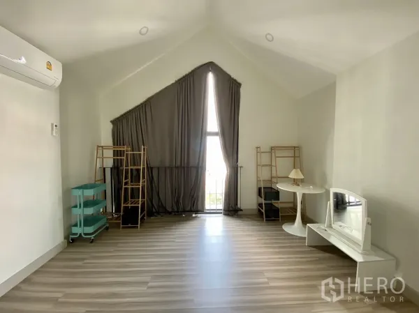 Home Office for rent or sale in Phra Khanong, Bangkok - Top-floor room with vaulted ceiling, balcony door and wood-look flooring.