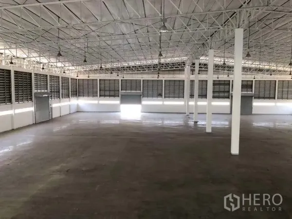 工厂 出租或出售在Phra Nakhon Si Ayutthaya - 开阔仓库内部，设有多樘卷闸门与百叶通风窗。