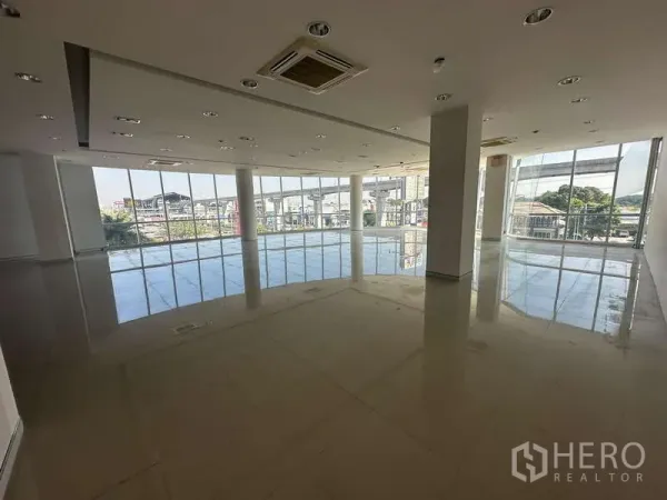 Office Space for rent in Prawet, Bangkok - Open-plan office with floor-to-ceiling windows overlooking Srinakarin and an elevated transit line.
