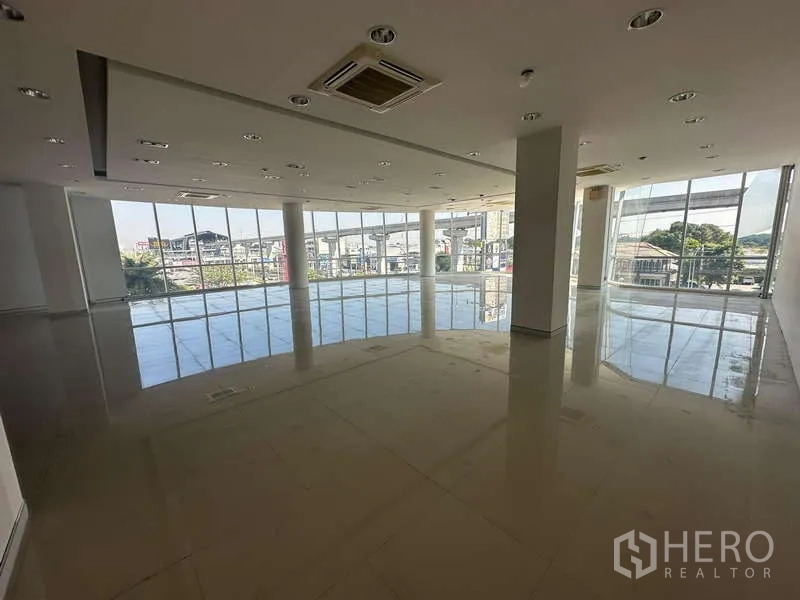 Office Space for rent in Prawet, Bangkok - Open-plan office with floor-to-ceiling windows overlooking Srinakarin and an elevated transit line.