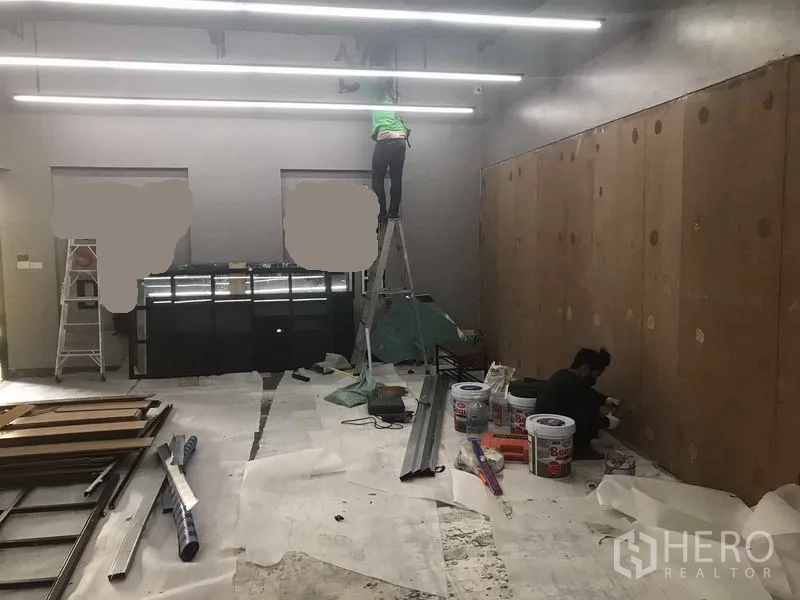 零售空间 出租在Watthana, Bangkok - 正在翻新中的零售单元，带木板墙、梯子和线性天花灯