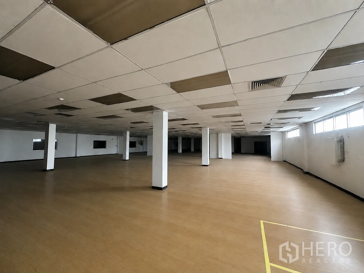 โรงงาน for rent or sale in Wang Noi, Phra Nakhon Si Ayutthaya - มุมมองอีกด้านของฮอลล์พื้นสีน้ำตาล เห็นหน้าต่าง ช่องลม และเสาโครงสร้าง
