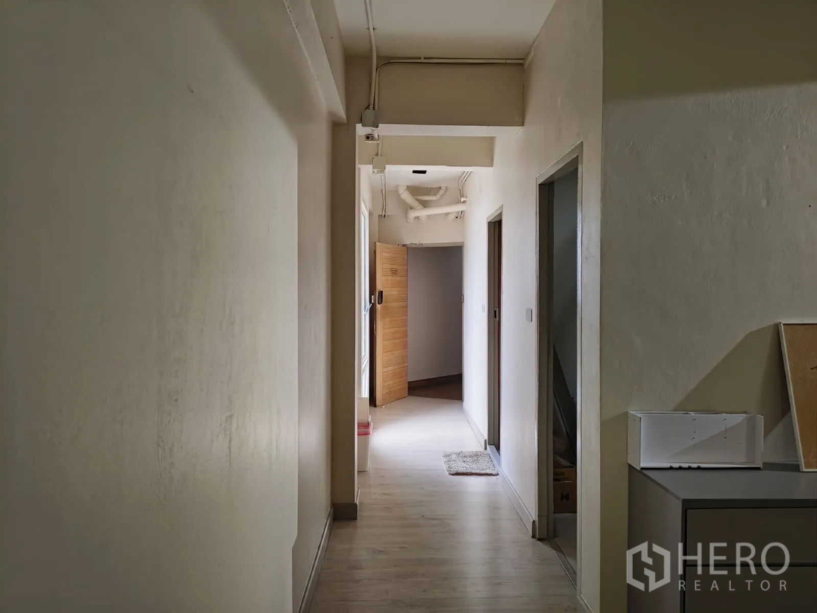 ตึกแถว for rent in Watthana, Bangkok - โถงทางเดินแคบมุ่งสู่ห้องต่างๆ พร้อมแสงสว่างนุ่มนวล.