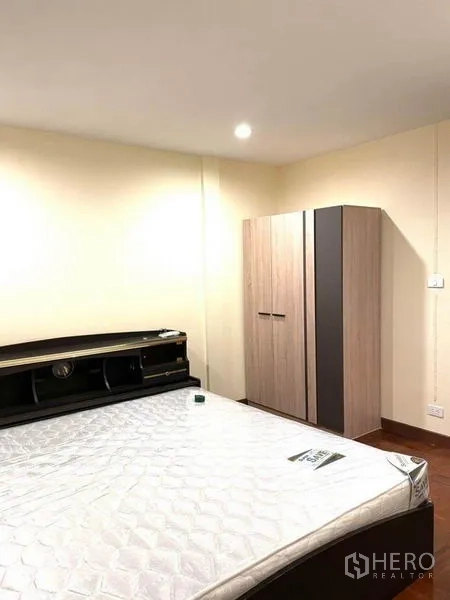 联排别墅 出租在Bang Na, Bangkok - 次卧配床架、独立衣柜与暖色灯光。