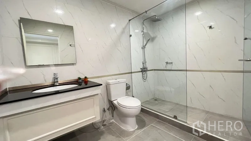 公寓 出租在Phra Khanong, Bangkok - 宽敞浴室，长台盆与玻璃步入式淋浴间