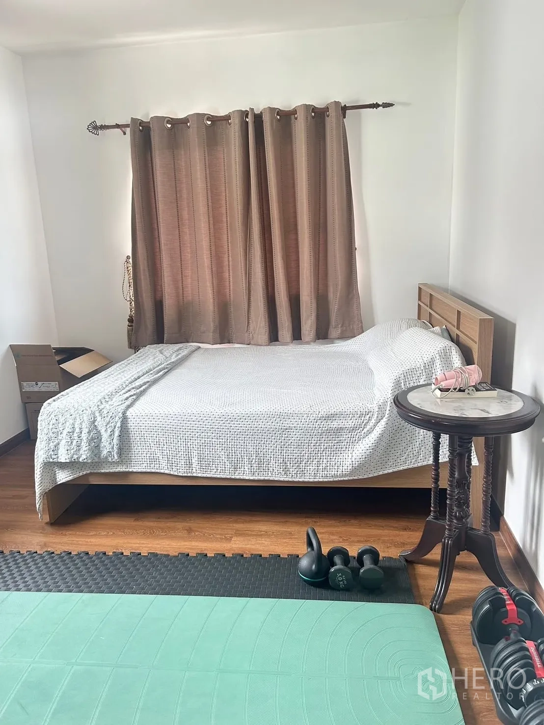 独栋房屋 for rent in Bang Na, Bangkok - 卧室铺木地板，双人床与床边桌，配运动垫与哑铃。