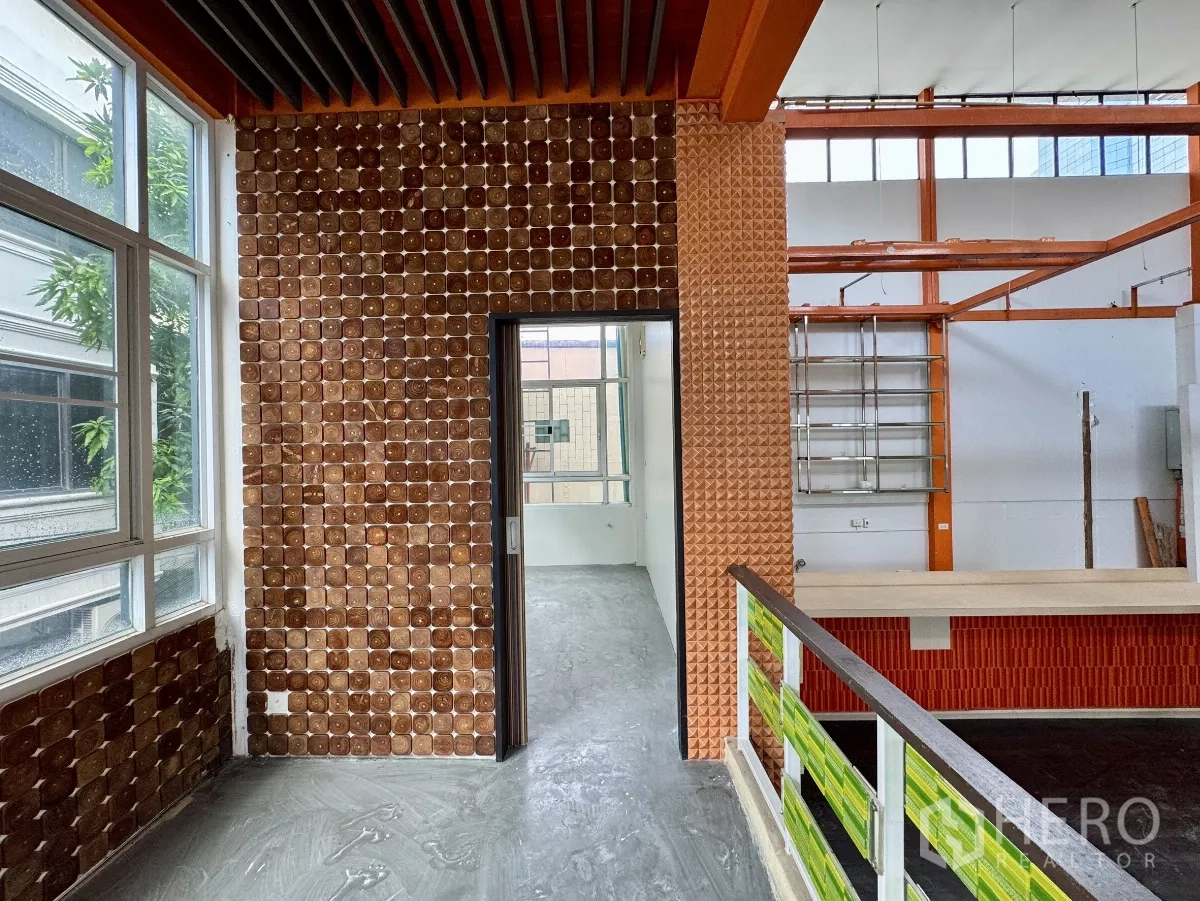 Shophouse for rent in Sathon, Bangkok - Landing area with patterned tile wall, doorway and mezzanine-style railing.