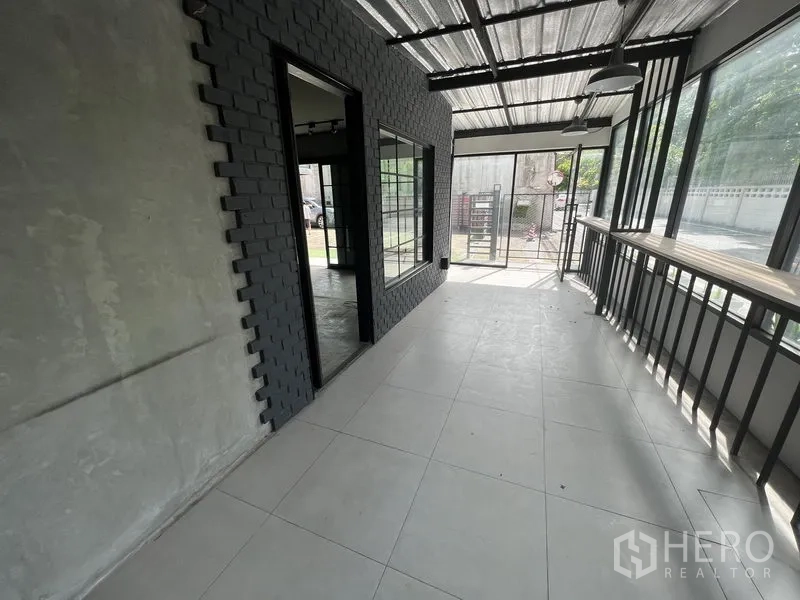 零售空间 出租在Watthana, Bangkok - 封闭式走廊，落地窗与金属屋顶，连接入口。