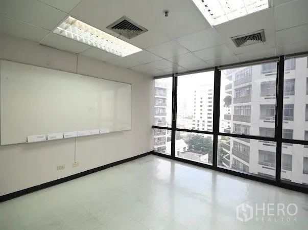 สำนักงาน ให้เช่าในWatthana, Bangkok - มุมทำงานสว่าง ช่องแอร์บนฝ้า ไฟฟลูออเรสเซนต์ และวิวเมืองผ่านหน้าต่างสูง