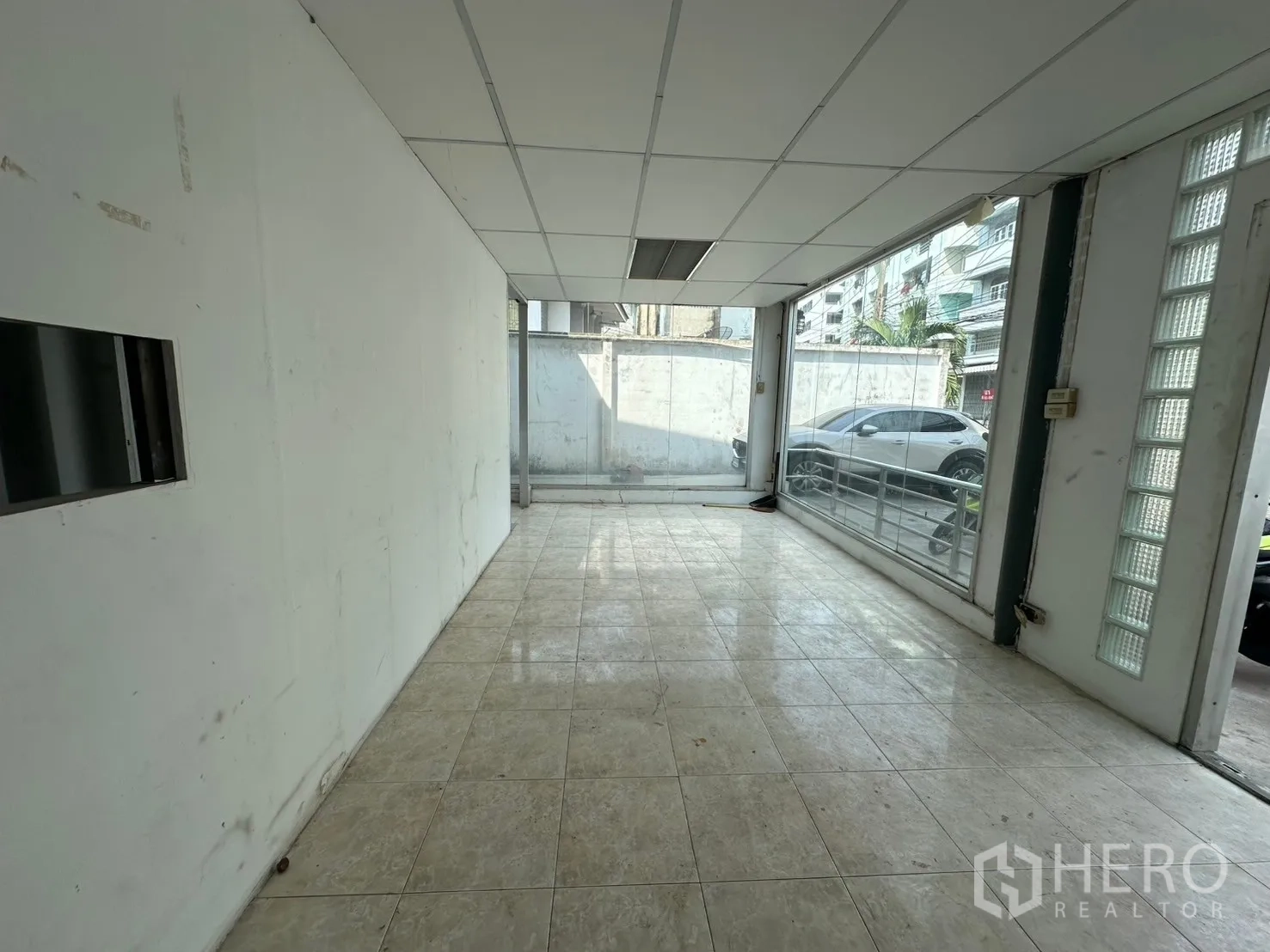 Warehouse for rent in Suan Luang, Bangkok - Ground-floor showroom or reception with floor-to-ceiling glass and tiled floor.