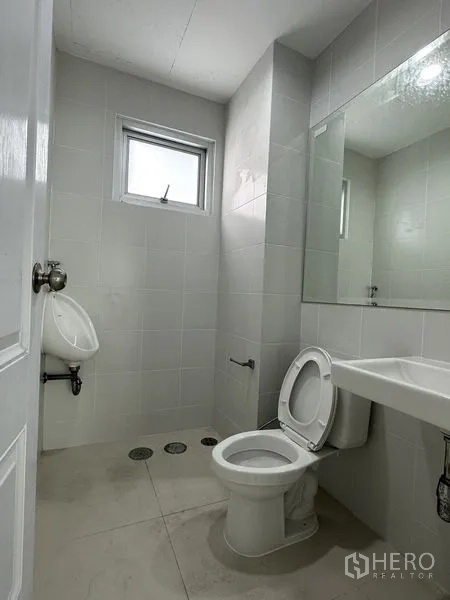 工厂 出租在Mueang Samut Prakan, Samut Prakan - 瓷砖卫生间，配坐便器、小便斗、洗手盆与通风窗。