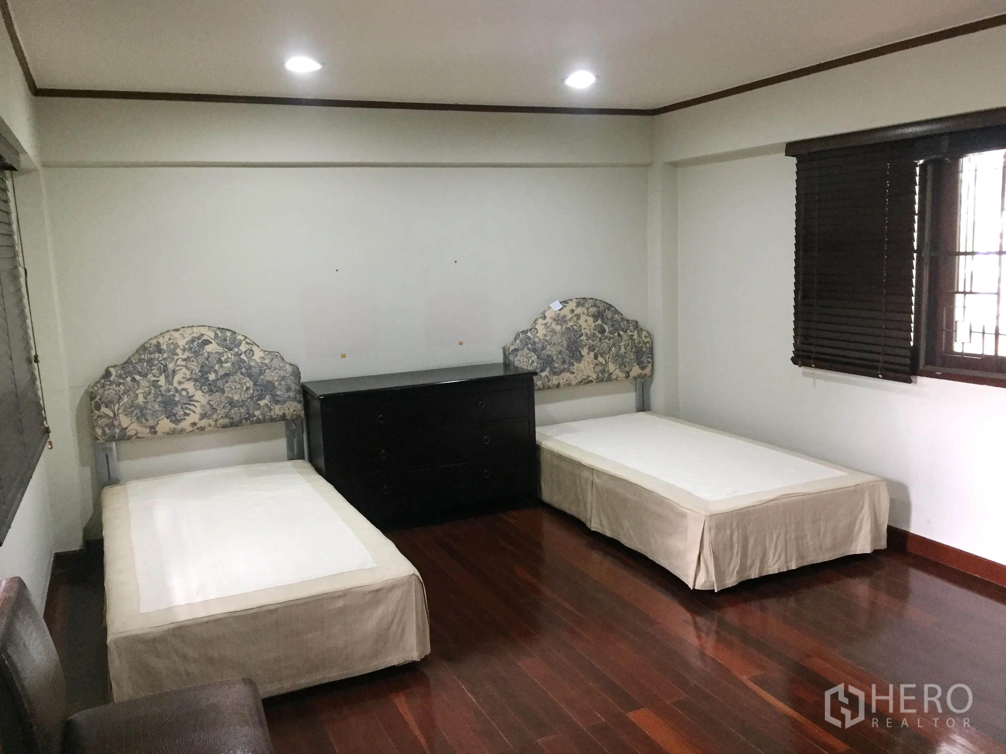 Detached House for rent in Khlong Toei, Bangkok - Spacious twin bedroom with two single beds and a chest of drawers.